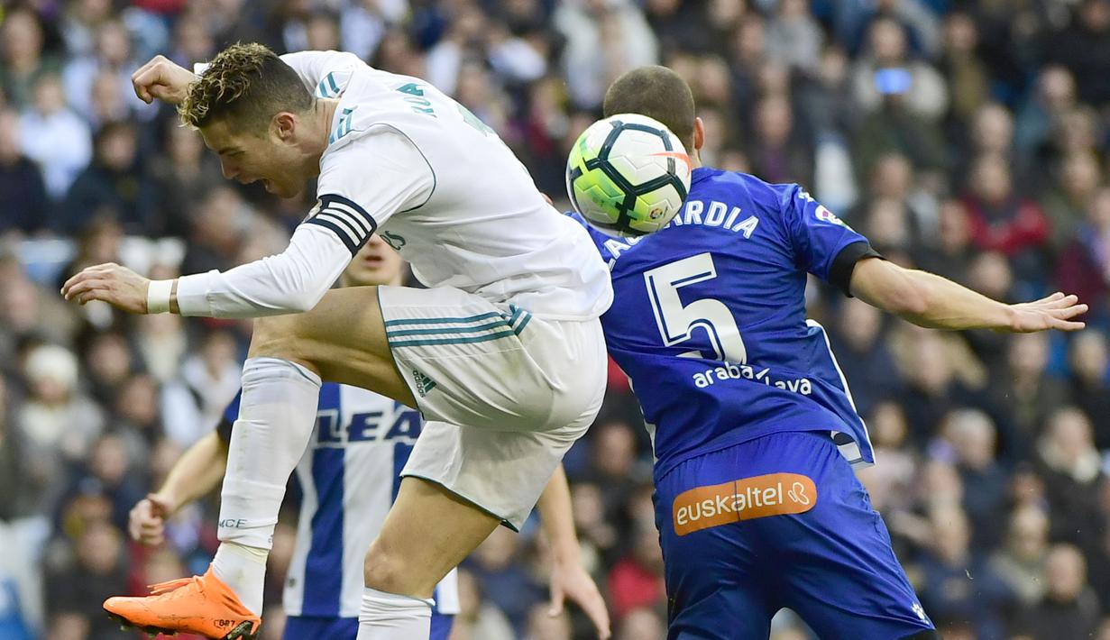 Aksi pemain Real Madrid, Cristiano Ronaldo (kiri) saat berebut bola dengan pemain Alaves, Victor Laguardia Cisneros (kanan) pada La Liga Santander di Santiago Bernabeu stadium, Madrid, (24/2/2018). Real Madrid menang 4-0. (AFP/ Pierre-Philippe Marcou)