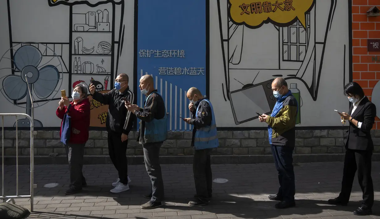 <p>Orang-orang memindai kode QR untuk mendaftar tes COVID-19 pada tempat pengujian setelah pihak berwenang memerintahkan putaran ketiga dari tiga tes COVID-19 berturut-turut untuk penduduk di Distrik Chaoyang, Beijing, China, Sabtu (7/5/2022). (AP Photo/Mark Schiefelbein)</p>
