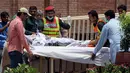 Petugas penyelamat dan staf rumah sakit Pakistan mengevakuasi korban ledakan truk tangki minyak di rumah sakit di Multan, Pakistan (25/6). Akibat insiden ini, sedikitnya 123 orang tewas dan 100 lainnya mengalami luka-luka.  (AP Photo / Adeel Khan)