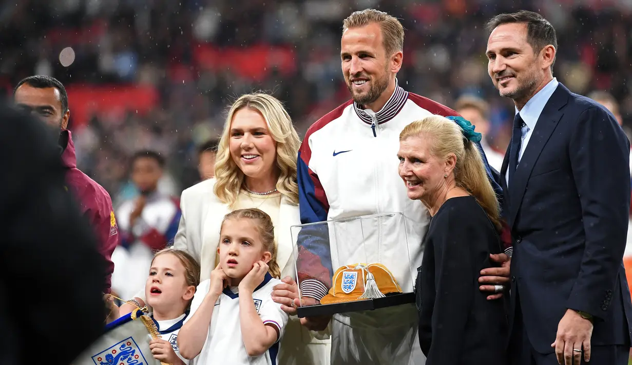 Pemain Inggris, Harry Kane berfoto bersama keluarganya saat menerima Cap ke-100 sebelum laga UEFA Nations League 2024 antara Inggris melawan Finlandia di Satdion Wembley, London, Rabu (11/09/2024) WIB. (AFP/Justin Tallis)