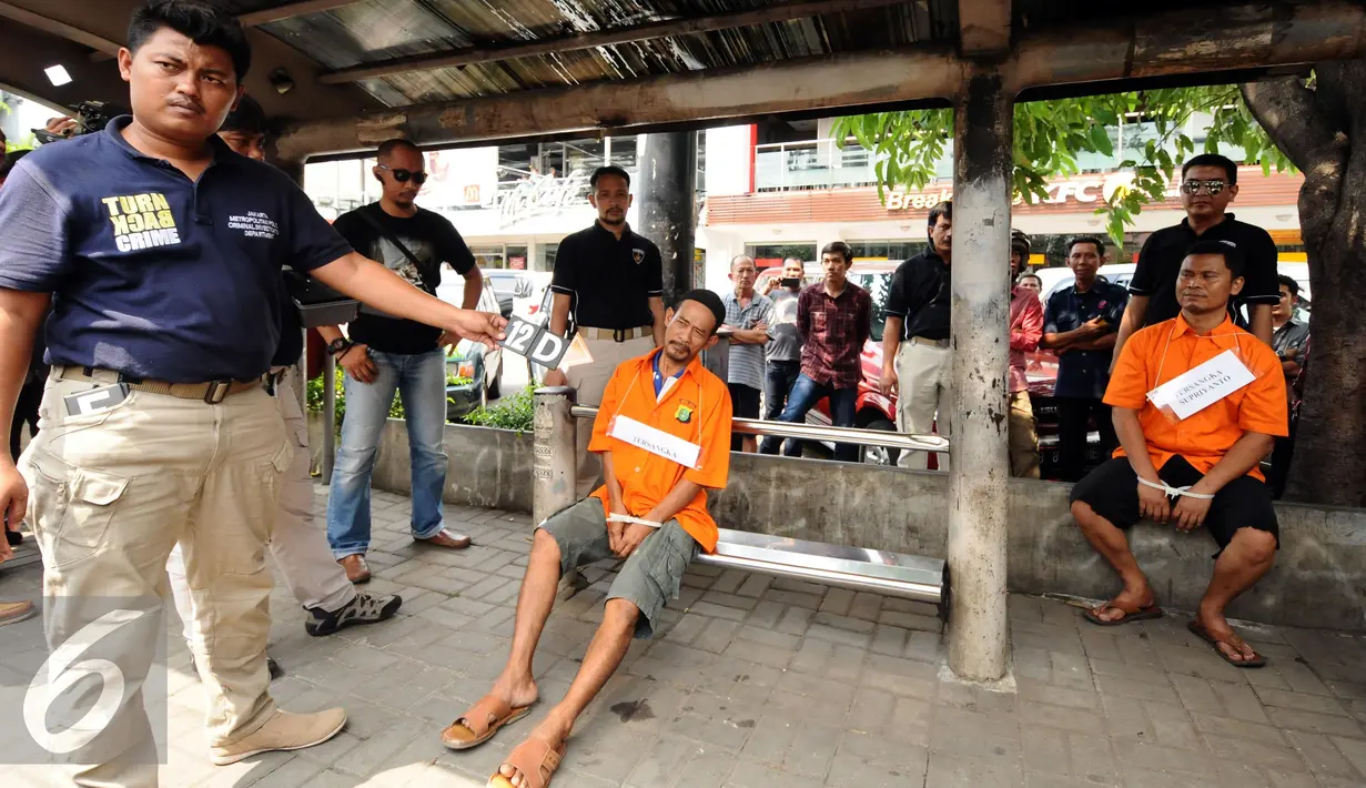 Dua tersangka kasus perampokan disertai penyanderaan memeragakan adegan pertemuan jelang melakukan aksinya di Jalan Metro Hijau IX, Jakarta, Selasa (13/9). 60 adegan reka ulang kejadian diperagakan tersangka. (Liputan6.com/Helmi Fithriansyah)