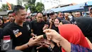 Cagub DKI Jakarta, Agus Harimurti Yudhoyono (kiri) menyalami warga saat sosialisasi di Jalan Menteng Tenggulun, Jakarta, Kamis (22/12). Agus bersosialisasi sambil berkeliling ke beberapa RW di kawasan tersebut. (Liputan6.com/Helmi Fithriansyah)