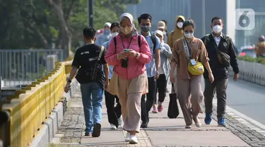 Pekerja berjalan menuju kantor mereka masing-masing di sepanjang Jalan Kawasan Sudirman-Thamrin, Jakarta, Senin (14/8/2023). (merdeka.com/Imam Buhori)