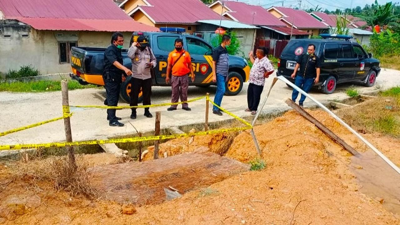 Personel Polsek Tenayan Raya, Pekanbaru, memasang garis polisi di septictank tempat dua bocah tenggelam.