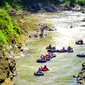 Tubing menyusuri derasnya aliran sungai Klawing. (Liputan6.com/Dinkominfo PBG/Muhamad Ridlo)