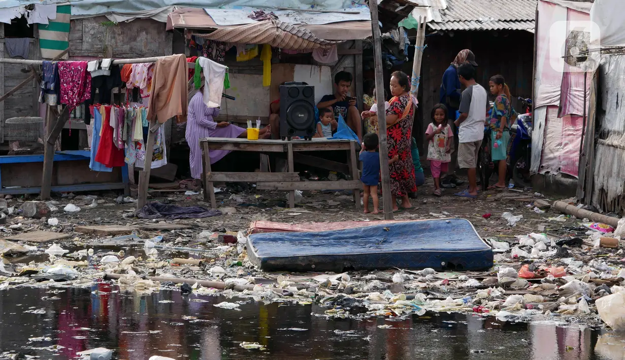 Warga melakukan aktivitas di daerah kumuh kawasan Jakarta, Kamis (13/1/2022). Pemerintah akan memperluas penanganan kemiskinan ekstrem menjadi 212 kabupaten/kota di 25 provinsi, di mana 147 kabupaten/kota di antaranya merupakan wilayah pesisir. (Liputan6.com/Angga Yuniar)