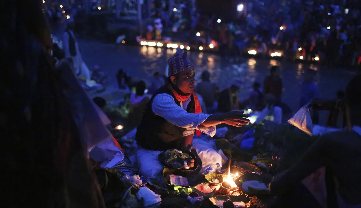 Seorang pendeta Nepal melakukan ritual untuk penyembah selama festival Kuse Aunsi di Kathmandu, Jumat (30/8/2019). Ritual dilakukan dengna menawarkan biji-bijian, sayuran dan buah-buahan kepada para pemuka agama yang hadir dalam perayaan. (AP Photo/Niranjan Shrestha)