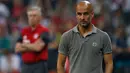 Pelatih baru Manchester City, Pep Guardiola terlihat lesu saat timnya tunduk atas Manchester City di laga pramusim di Allianz Arena, Muenchen (21/7). Ini menjadi pertandingan debut Pep Guardiola sebagai manajer The Citizens. (Reuters/Michaela Rehle)