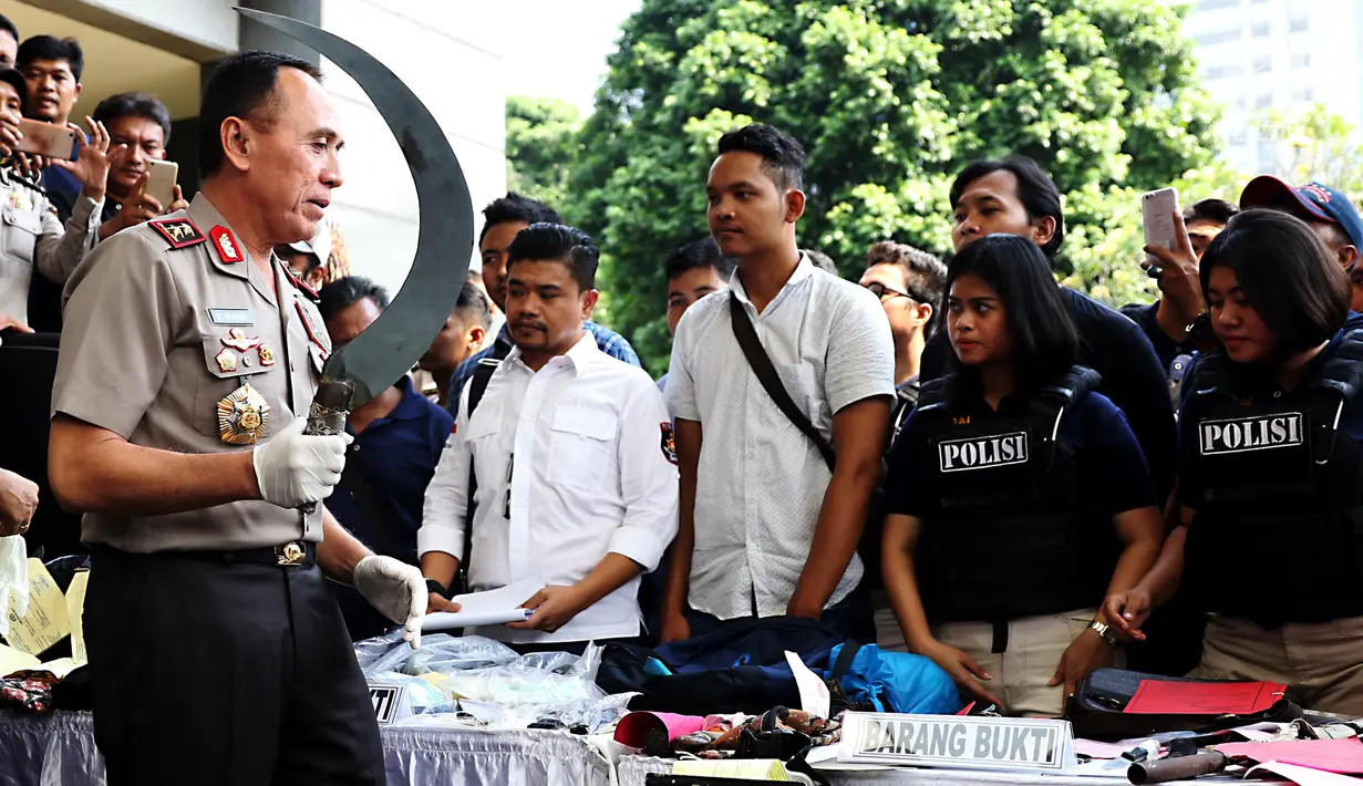 Kapolda Metro Jaya Irjen Mochammad Iriawan memegang barang bukti senjata tajam saat rilis hasil operasi cipta kondisi Ramadan di Polda Metro Jaya, Rabu (21/6). Puluhan preman terjaring operasi yang digelar sejak akhir Mei lalu. (Liputan6.com/Angga Yuniar)