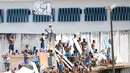 Para tahanan berada diatas atap usai bentrokan antar dua geng narkoba di penjara Alcacuz, Rio Grande do Norte, Brasil, (16/1). Sebagian besar jenazah ditemukan dalam kondisi termutilasi. (AFP Photo/Andressa Anholette)