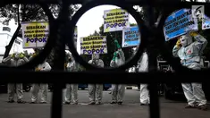 Sejumlah Aktivis Lingkungan menggunakan pakaian antiradiasi dan masker melakukan aksi protes pencemaran sungai Brantas di Kementerian Pekerjaan Umum dan Perumahan Rakyat, Jakarta, Jumat (19/1). (Liputan6.com/Johan Tallo)