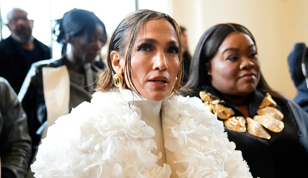 Walau hanya dengan warna monokrom, pelantun lagu Can't Get Enough menarik perhatian dengan jaket putih berhias kelopak bunga mawar dengan detail bordir berpayet perak di punggung. Didandani stylist Mariel Haenn, ia memadukannya dengan sweater turtleneck dan high-waisted legging hitam. (AP Photo/Christophe Ena)
