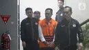 Bupati Cilacap, Jawa Tengah, Syamsul Auliya Rachman saat digiring petugas menuju mobil tahanan di Gedung Merah Putih Komisi Pemberantasan Korupsi (KPK), Jakarta, Sabtu (14/3/2026). Komisi Pemberantasan Korupsi (KPK) resmi menahan dua tersangka terkait dugaan pemerasan dan penerimaan lainnya di lingkungan Pemerintah Kabupaten Cilacap, Jawa Tengah. (Liputan6.com/Helmi Fithriansyah)