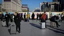 Pelancong menunggu jadwal keberangkatan kereta mereka di luar pintu masuk stasiun kereta api Beijing, Jumat (10/1/2020). Puluhan ribu warga China telah memulai migrasi manusia terbesar di dunia meninggalkan kota-kota besar menuju kampung halaman untuk merayakan Tahun Baru Imlek. (WANG ZHAO/AFP)