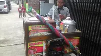 Nampak pedagang cilok keliling tengah melayani pembeli (Liputan6.com/Jayadi Supriadin)