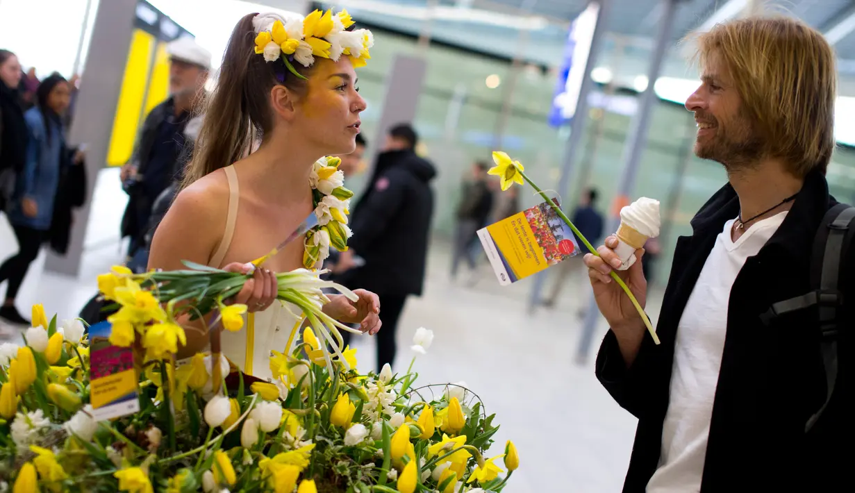 Model berbincang dengan pengunjung saat berlangsungnya pameran bunga Keukenhof di Central Station di Utrecht, Belanda, (29/3). Pameran ini menghadirkan sekitar 20.000 bunga musim semi. (AP Photo / Peter Dejong)