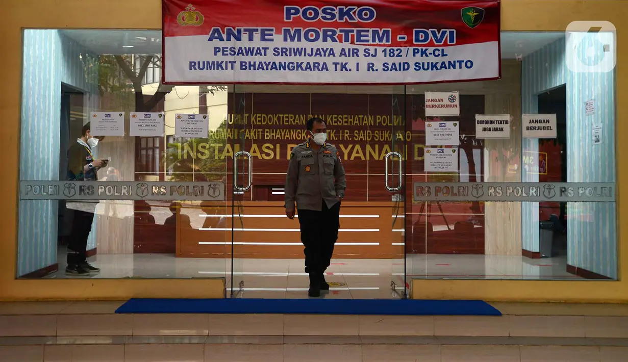 Seorang polisi berjalan di Posko Ante Mortem-DVI RS Polri Jakarta, Selasa (12/1/2021). Hingga saat ini, tim DVI masih mengumpulkan sampel DNA penumpang pesawat Sriwijaya Air SJ 182 yang jatuh di perairan Kepualauan Seribu. (merdeka.com/Imam Buhori)