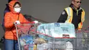 Seorang wanita mendorong troli berisi barang-barang kebutuhan sehari-hari di luar gudang Costco di Vancouver, Kanada, pada 14 Maret 2020. Lebih dari 200 kasus virus corona COVID -19 telah dilaporkan di Kanada. (Xinhua/Liang Sen)
