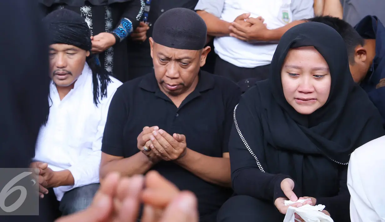 Artis komedi Tukul Arwana bersama anaknya berdoa saat pemakaman istrinya, Susiana, di TPU Tanah Kusir, Jakarta, Rabu (24/8). Susiana wafat di usia 48 tahun akibat penyakit asma yang dideritanya. (Liputan6.com/Immanuel Antonius)