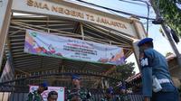 Personel militer berjaga di gerbang sebuah sekolah setelah ledakan di Jakarta, Indonesia, Minggu, 9 November 2025. Hingga Minggu (9/11/2025), SMAN 72 Jakarta di Kelapa Gading, Jakarta Utara, masih dijaga ketat Polisi Militer TNI Angkatan Laut (POMAL). (AP Photo/Achmad Ibrahim)