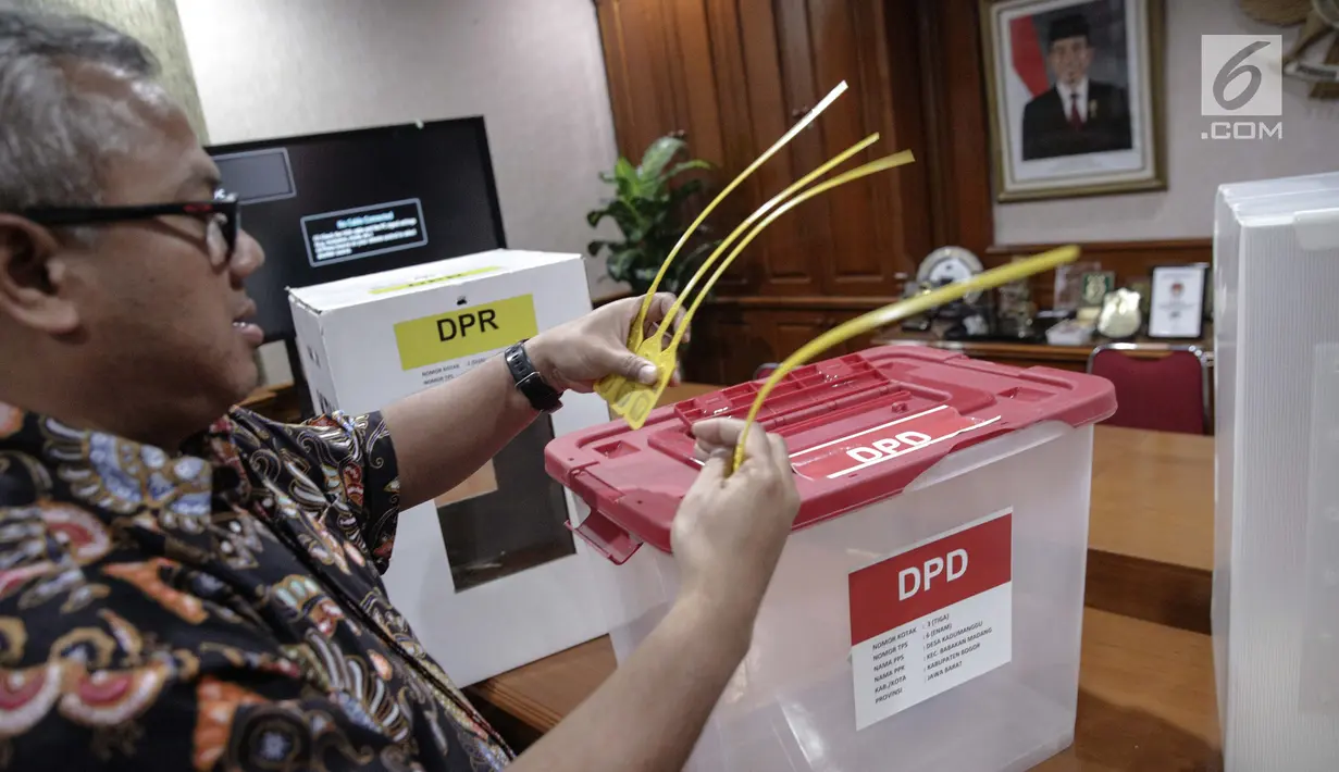 Ketua KPU Arief Budiman memeriksa ikatan pengaman kotak suara Pemilu 2019 di kantor KPU, Jakarta, Kamis (16/11). KPU melalui rapat pleno telah memutuskan kotak suara karton kedap air yang digunakan pada Pemilu 2019. (Liputan6.com/Faizal Fanani)