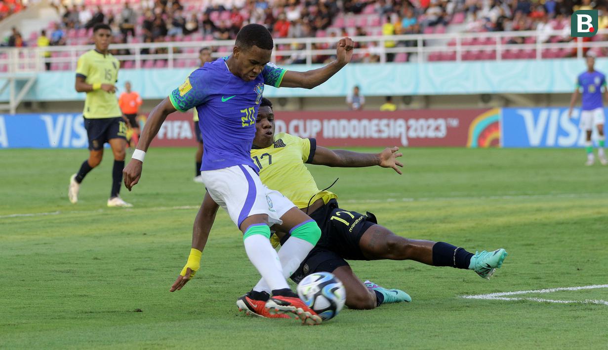 <p>Pemain Timnas Ekuador U-17, Yorkaeff Caicedo (kanan) berusaha menghalau bola tendangan pemain Brasil U-17, Estevao dalam pertandingan babak 16 Besar Piala Dunia U-17 di Stadion Manahan, Solo, Senin (20/11/2023). (Bola.com/Arief Bagus)</p>