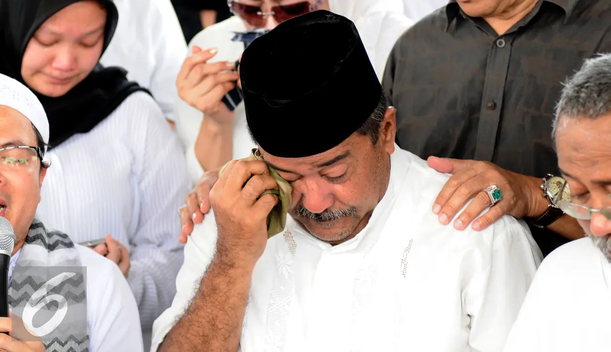Gubernur Banten, Rano Karno mengusap air mata saat pemakaman ibunya, Lily Soekarno M Noor di TPU Tanah Kusir Jakarta, Senin (7/12/2015). Ibunda Rano Karno wafat di usia 77 tahun akibat komplikasi penyakit. (Liputan6.com/Helmi Fithriansyah)