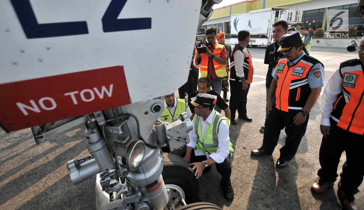Menteri Perhubungan (Menhub) Budi Karya Sumadi mengecek roda pesawat saat meninjau pelayanan arus mudik di Bandara Halim Perdanakusuma, Jakarta, Senin (11/6). (Merdeka.com/Iqbal Nugroho)
