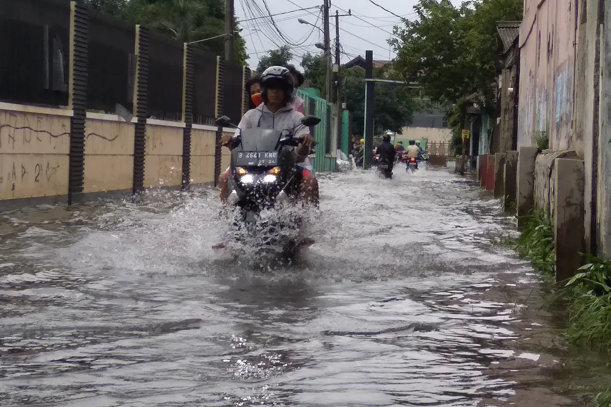 Warga berjalan menerobos banjir setinggi satu meter di Perumahan Rawalumbu Utara BBU Pasar Burung, Kota Bekasi. Foto: Liputan6.com/Bam Sinulingga)