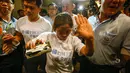 Wajah kekecewaan juga tampak pada wanita ini. Ia mengangkat tangannya ke arah media sambil terus berlalu sebagai bentuk penolakan untuk memberikan pernyataan pada wartawan (REUTERS/Athit Perawongmetha)