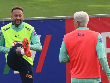 Penyerang timnas Brasil Neymar melakukan peregangan saat sesi latihan di tempat latihan Continassa di Turin, Italia, Selasa (15/11/2022). Timnas Brasil memusatkan latihan mereka jelang pelaksanaan turnamen akbar Piala Dunia 2022 Qatar. (Vincenzo PINTO / AFP)