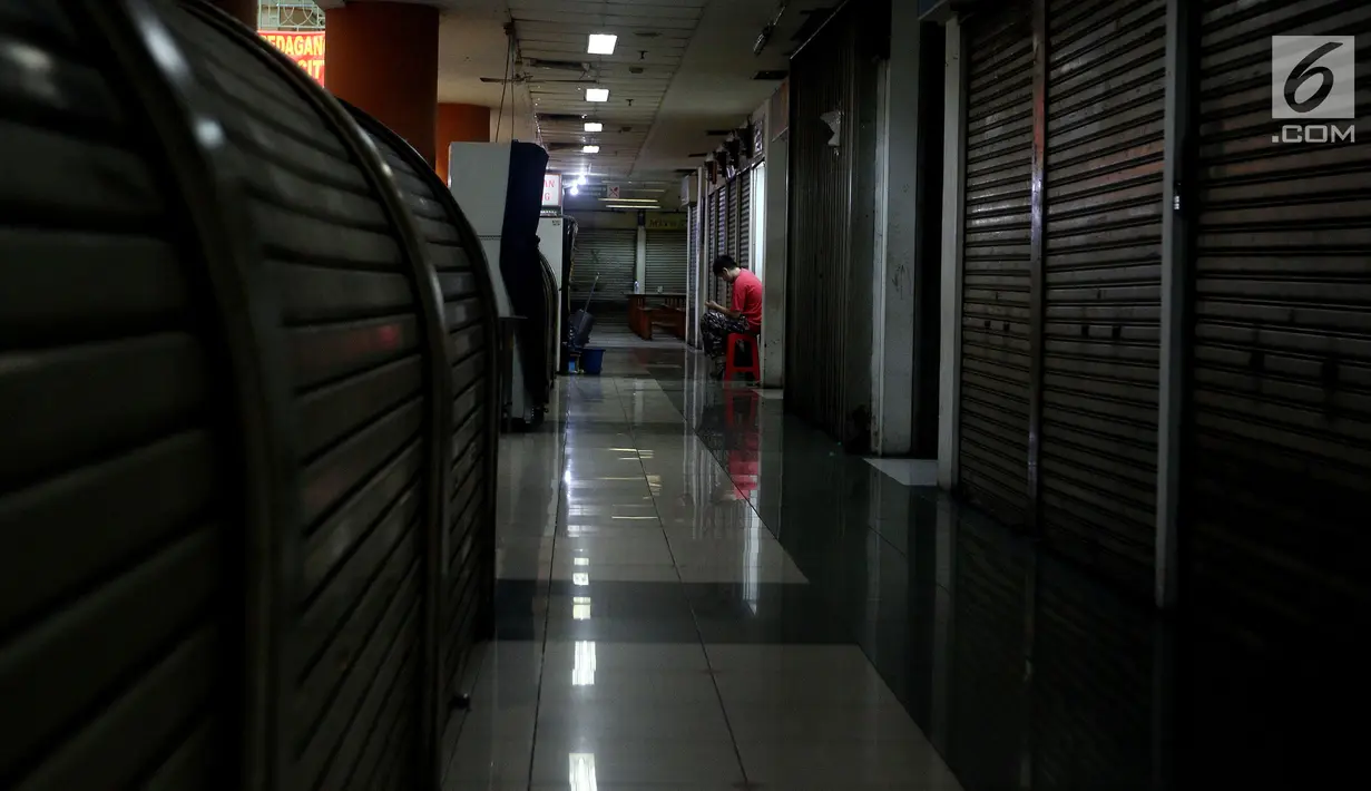 Seorang pedagang duduk di depan tokonya di pertokoan elektronik Glodok, Jakarta, Minggu (17/6). Hampir 90 persen pertokoan di Glodok tutup pada Lebaran tahun ini. (Liputan6.com/JohanTallo)