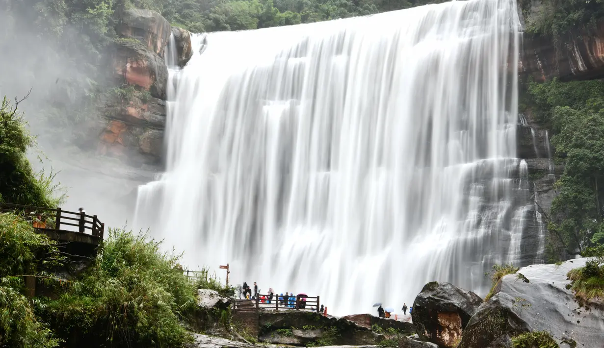 Sejumlah wisatawan mengamati air terjun Chishui di Kota Zunyi, Provinsi Guizhou, China barat daya (7/10/2020). Terkenal karena kekayaan sejarah dan sumber daya alamnya, Kota Zunyi menarik banyak wisatawan selama libur Hari Nasional dan Festival Pertengahan Musim Gugur. (Xinhua/Yang Wenbin)