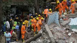 Tim penyelamat mencari korban lainnya dalam puing-puing bangunan di Mumbai, India, Selasa (25/7). Sebuah gedung penghunian lima lantai runtuh pada selasa pagi waktu setempat. (AP/Rafiq Maqbool) 