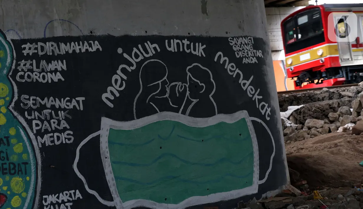 KRL melintas di dekat mural bertema pencegahaan penyebaran virus Corona atau COVID-19 di Jakarta, Selasa (7/4/2020). Mural tersebut menghimbau masyarakat untuk menjaga jarak fisik dan selalu menggunakan masker serta tetap beraktivitas di dalam rumah. (Liputan6.com/Helmi Fithriansyah)