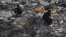 Seorang wanita Palestina yang terpaksa mengungsi duduk di atas puing-puing bangunan yang hancur di kawasan Sheikh Radwan yang parah kerusakannya di Kota Gaza, Sabtu 11 Oktober 2025. (AP Photo/Abdel Kareem Hana)
