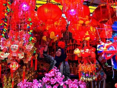 Seorang perempuan melihat pernak-pernik Imlek yang dijual di kawasan Glodok, Jakarta, Senin (13/1/2020). Menyambut tahun baru Imlek pada 25 Januari mendatang, penjualan pernak-pernik imlek dijual dengan harga Rp 5ribu hingga jutaan rupiah per buah tergantung jenis. (merdeka.com/Arie Basuki)