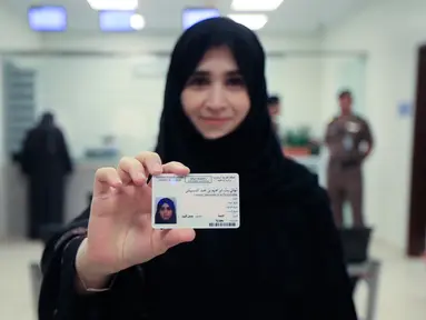 Tahani Aldosemani memperlihatkan surat izin mengemudi (SIM) miliknya di Departemen Lalu Lintas Umum di ibu kota Riyadh, Senin (4/6). Pemerintah Arab Saudi resmi mengeluarkan lisensi mengemudi untuk para wanita di sana. (Saudi Information Ministry via AP)