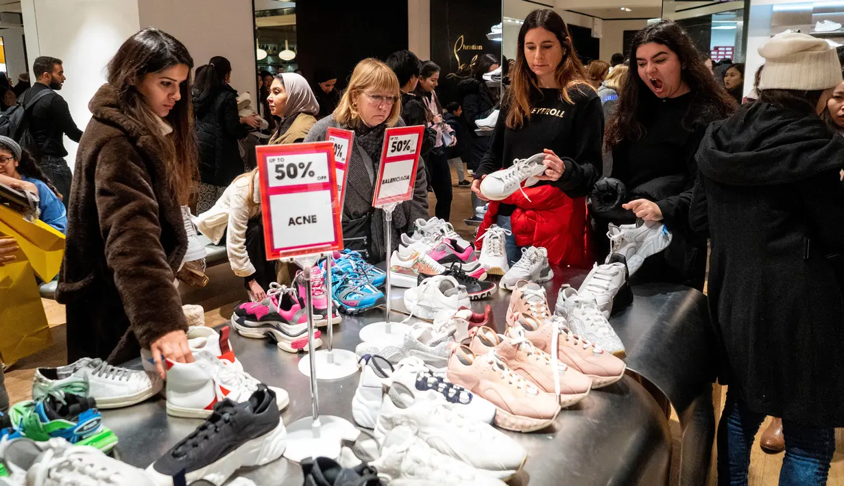 Pemburu diskon melihat sepatu selama Boxing Day di department store Selfridges, London, Kamis (26/12/2019). Boxing Day merupakan tradisi hari belanja terbesar tahunan yang diperingati setiap 26 Desember atau sehari setelah Natal dan menjadi hari libur nasional di Inggris. (Niklas HALLE'N/AFP)