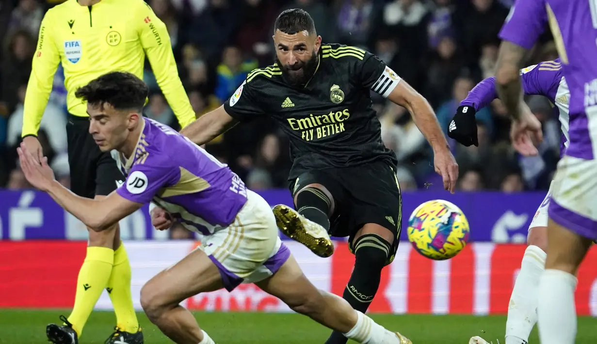 Penyerang Real Madrid asal Prancis Karim Benzema menembak ke gawang Real Valladolid dalam duel pekan ke-15 La Liga 2022/23 di Stadion Nuevo Jose Zorrilla, Valladolid, Sabtu (31/12/2022) dini hari WIB. Kemenangan ini mengantar Madrid menyalip Barcelona di puncak klasemen sementara Liga Spanyol 2022/23. (CESAR MANSO / AFP)