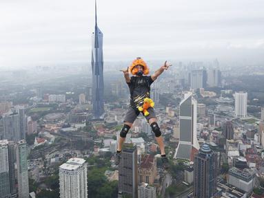 Seorang pelompat BASE terjun dari Menara Kuala Lumpur selama KL Tower International Jump Malaysia di Kuala Lumpur, Jumat (3/2/2023). Event wisata olahraga ini mengajak traveler penantang adrenalin untuk base jump, semacam terjun bebas, dari sisi atas menara di ketinggian sekitar 300 meter. (AP Photo/Vincent Thian)