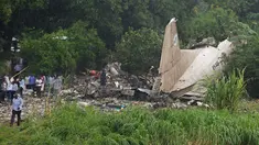 Tampak ekor pesawat kargo buatan Rusia beserta puing - puing yang berserakan di wilayah Juba, Sudan Selatan, Rabu (4/11/2015). Pesawat buatan Rusia yang jatuh tersebut menewaskan sedikitnya 25 orang. (AFP PHOTO/Charles Lomodong)