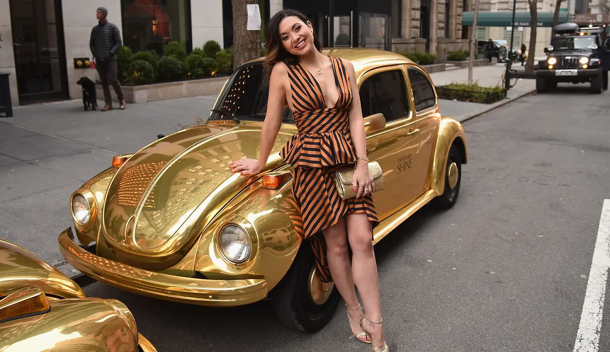 Evelyn Torres berpose dengan mobil kodok berwarna emas saat menghadiri peluncuran Shine Collection Pandora Jewelry di New York City (14/3). Pandora Shine mengeluarkan koleksi terbarunya, perhiasan emas 18 karat. (Bryan Bedder/Getty Images/AFP)