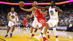 Pebasket Houston, Ryan Anderson #33 mencoba melewati adangan pebasket Warriors, Draymond Green #23 pada laga perdana NBA 2017 di Oracle Arena, Oakland, (17/10/2017).  Rockets menang 122-121.   Rockets menang 122-121. (Ezra Shaw/Getty Images/AFP)