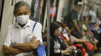 Warga memakai masker saat berada di dalam kereta api, Singapura (25/9/2015). Menurut Badan Lingkungan Nasional Singapura kabut Polutan Standar Indeks (PSI) mencapai tinggi 341 pada hari Jumat. (REUTERS/Edgar Su)