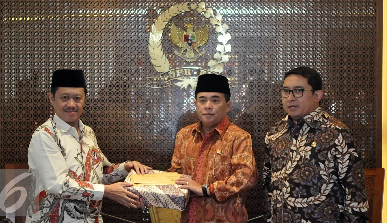 Pimpinan Komisi Yudisial (KY) Aidul Fitriciada Azhari memberikan cendera mata saat bertemu Ketua DPR Ade Komarudin (tengah) di Kompleks DPR, Senayan, Jakarta, Kamis (30/6). (Liputan6.com/Johan Tallo)