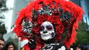 Seorang wanita berpakaian seperti "Catrina" ambil bagian dalam parade catrinas atau Hari Orang Mati di Reforma Avenue, Mexico City, 21 Oktober 2018. Hari kematian ini merupakan tradisi Halloween ala warga Hispanik di Meksiko. (RODRIGO ARANGUA/AFP)