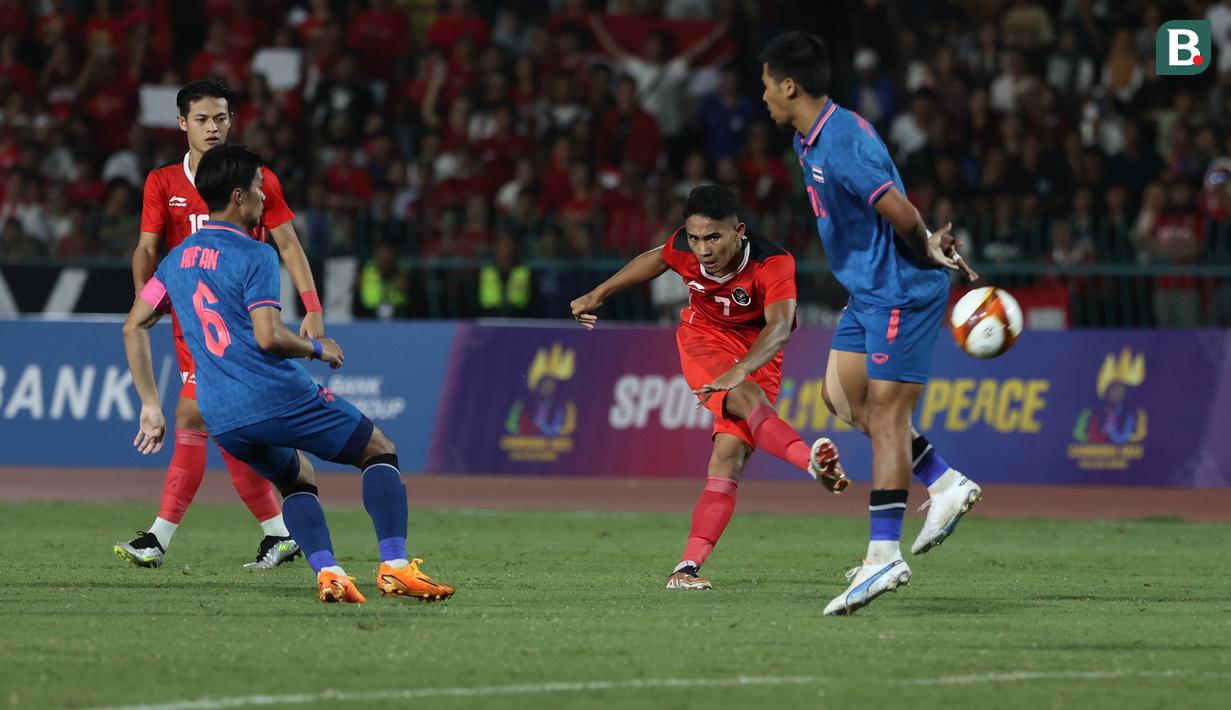 <p>Gelandang Timnas Indonesia U-22, Marselino Ferdinan (kedua kanan) melepaskan tendangan ke gawang Thailand pada laga final cabor sepak bola SEA Games 2023 di National Olympic Stadium, Phnom Penh, Kamboja, Selasa (16/5/2023). (Bola.com/Abdul Aziz)</p>