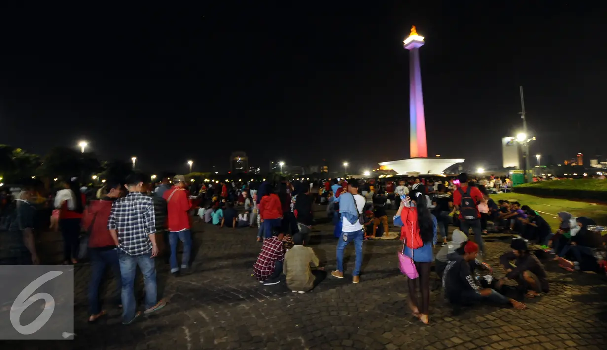 Pengunjung memadati halaman Monumen Nasional, Jakarta, Sabtu (31/12). Dengan alasan keamanan, Pemprov DKI Jakarta membatalkan panggung hiburan malam pergantian tahun di kawasan Monumen Nasional. (Liputan6.com/Helmi Fithriansyah)