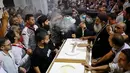 Suasana pemakaman korban tewas dalam kebakaran gereja kristen koptik di Gereja Santa Perawan Maria, Kairo, Provinsi Giza, Mesir, 14 Agustus 2022. Presiden Mesir Abdel Fattah El Sisi berkata peristiwa kebakaran itu adalah "kecelakaan tragis" dan meminta lembaga-lembaga terkait untuk mengurusnya, serta memberikan perawatan kepada korban luka. (Khaled DESOUKI/AFP)